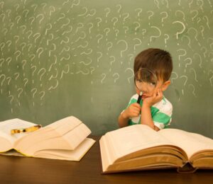 ילד תמה אוחז בספר, המסמל את הבלבול בין לקויות למידה לקשיי למידה.